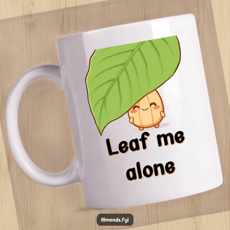 Funny mug with a grinning almond character playfully peeking out from behind a large green leaf, full of mischief.