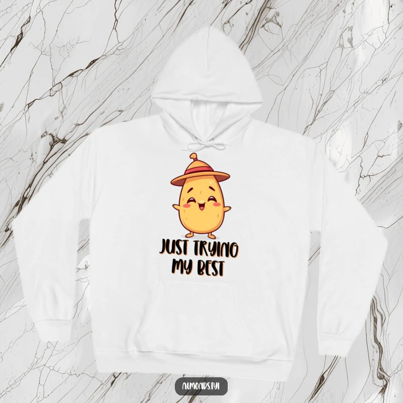 Funny hoodie with a mischievous almond character trying to balance a tiny hat, perfect for cozy and playful days.