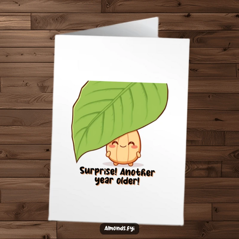 Funny Free Printable Birthday Card: A grinning almond character peeking mischievously from behind a large green leaf.